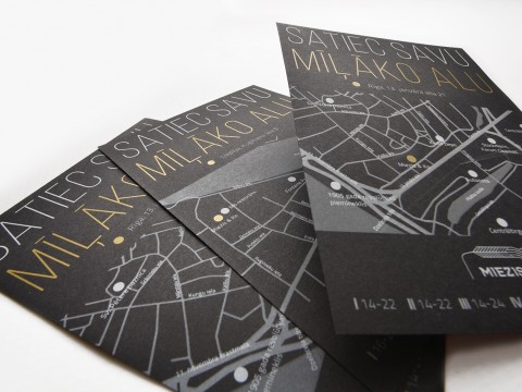 The flyer is printed with white and gold on black paper